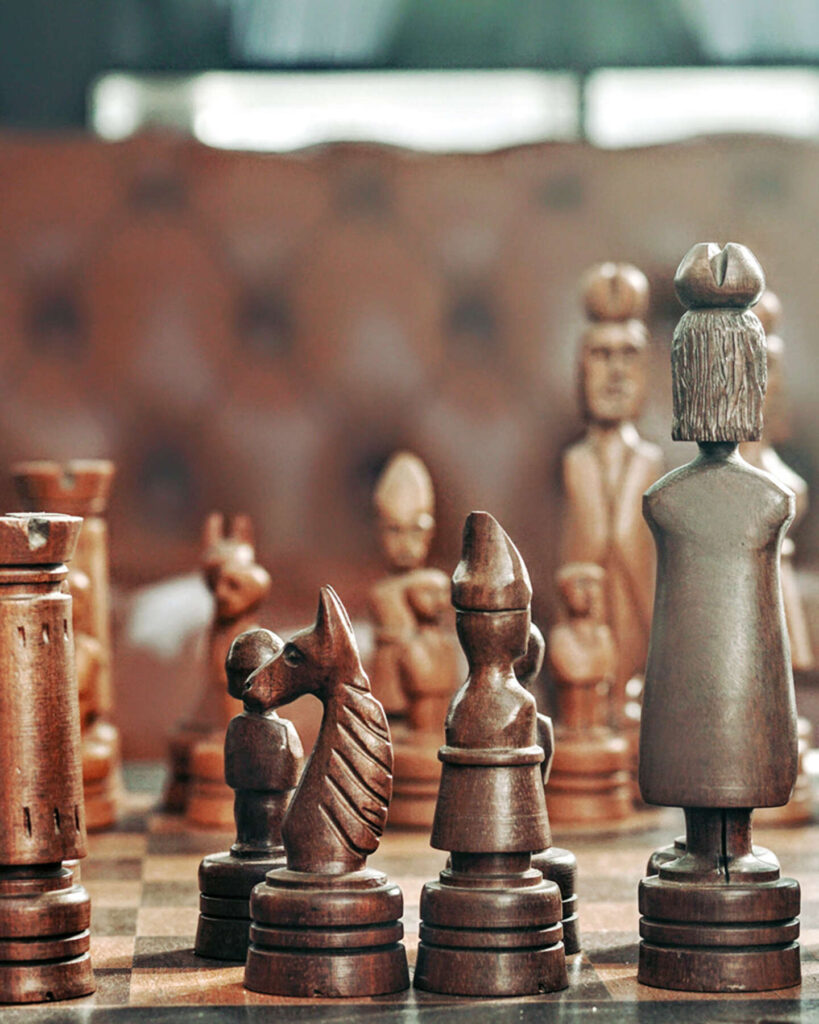 A close-up of a wooden chess set featuring intricately carved pieces on a chessboard.
